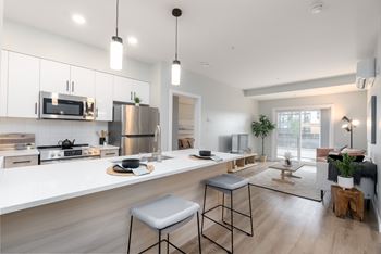 A modern kitchen with a stainless steel refrigerator and a white countertop.
